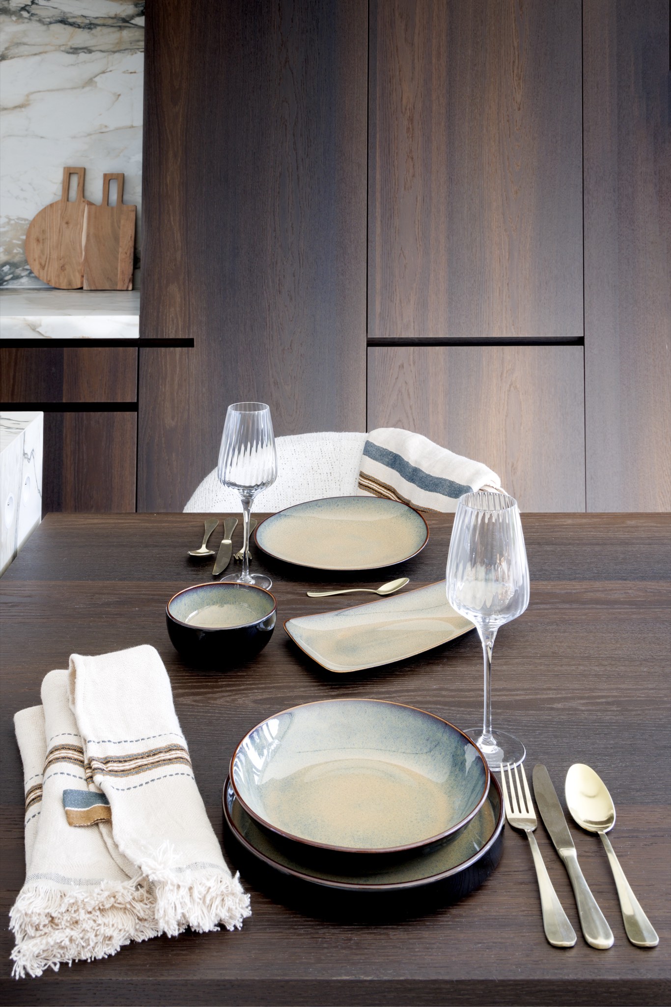 Gedekte eettafel met aardewerk en messing bestek